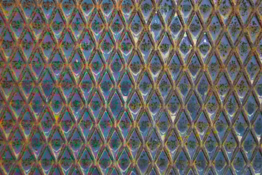 a close up of a metal surface with blue and yellow colors photo
