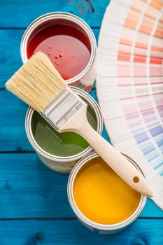 Paint cans color palette, cans opened with brushes on blue table photo