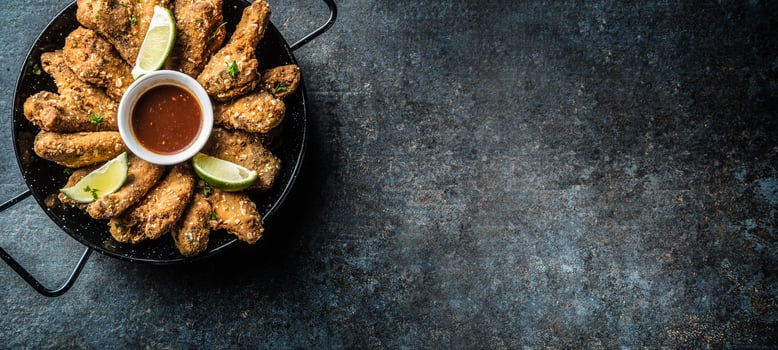Fried chicken wings chili sauce lime and potato fries. photo