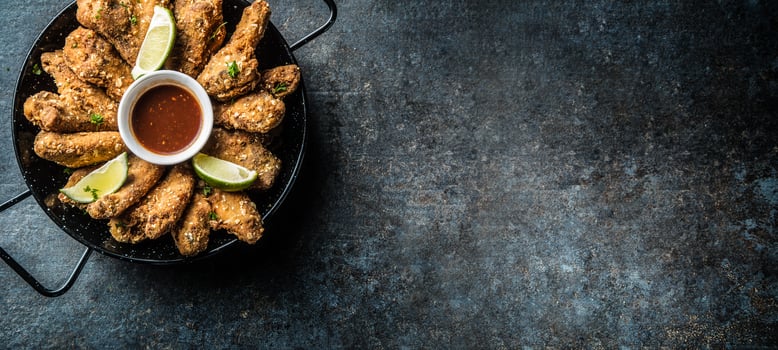 Fried chicken wings chili sauce lime and potato fries. photo