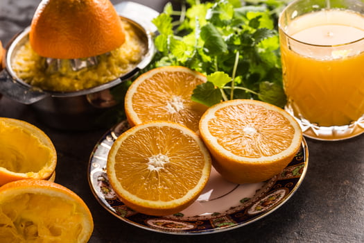 Fresh oranges juicer juice tropical fruits and herbs on concrete board photo