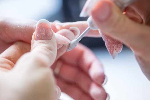 Repairing old gel nails with a nail grinder in nail studio - salon. Nails manicure. photo