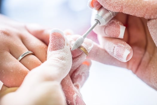 Repairing old gel nails with a nail grinder in nail studio - salon. Nails manicure. photo