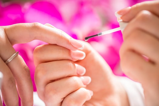 Manicure specialist painting woman gel nail. Art - French manicure photo