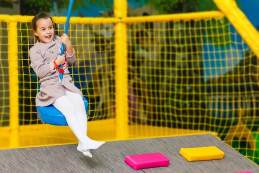 Little pretty girl is having fun outdoor. Playing in children zone in amusement park. photo