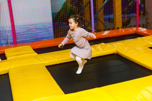 Little pretty girl is having fun outdoor. Playing in children zone in amusement park. photo