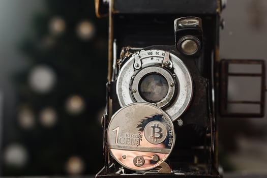 Camera can make money. Concept of Golden bitcoin coins symbolizes elements of virtual economy or crypto currency and vintage film camera photo