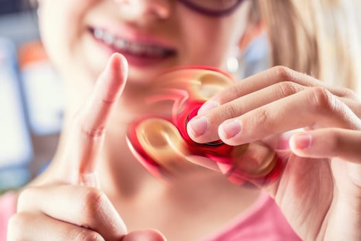 Fidget Spinner. Cute young girl playing with fidget spinner. photo