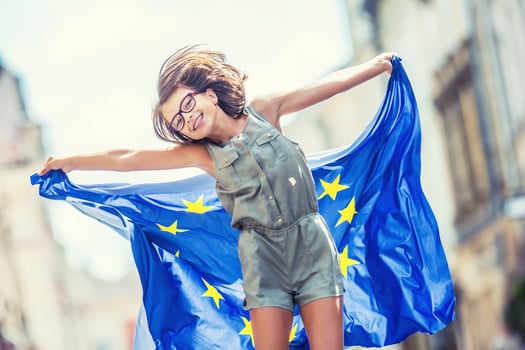 EU Flag. Cute happy girl with the flag of the European Union. Young teenage girl waving with the European Union flag in the city photo