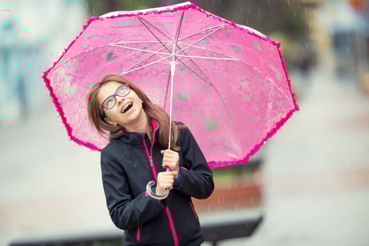 Portrait of happy beautiful young pre-teen girl with pink umbrella under rain. photo