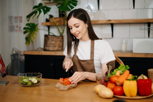 young woman with cutting board of cut lettuce at kitchen. healthy food concept photo