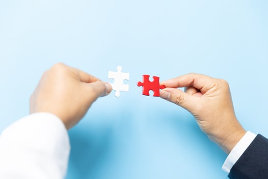 Two hands trying to connect couple puzzle piece on blue background. Teamwork concept. Closeup hand of connecting jigsaw puzzle. photo