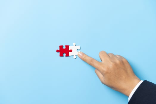 Two hands trying to connect couple puzzle piece on blue background. Teamwork concept. Closeup hand of connecting jigsaw puzzle. photo