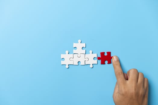 Two hands trying to connect couple puzzle piece on blue background. Teamwork concept. Closeup hand of connecting jigsaw puzzle. photo