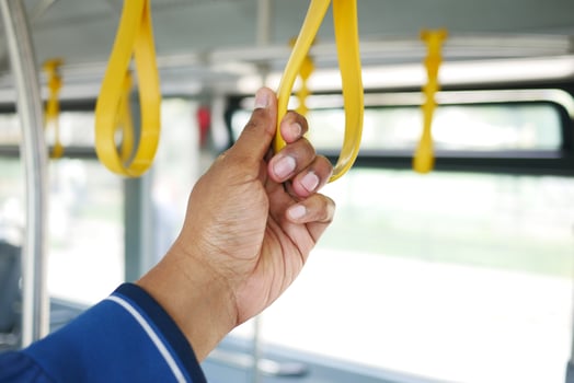 people holding onto a handle on a bus . photo