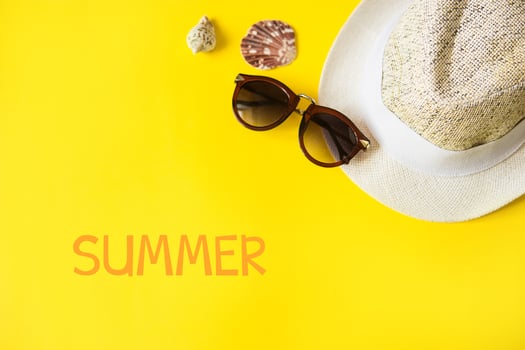 Beach accessories on the yellow background - sunglasses and striped hat. Summer is coming concept.Tropical leaves Monstera. Summer flat lay, top view. Text Summer. photo