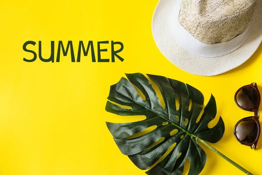 Beach accessories on the yellow background - sunglasses and striped hat. Summer is coming concept.Tropical leaves Monstera. Summer flat lay, top view. Text Summer. photo