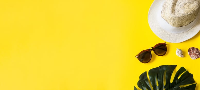 Beach accessories on the yellow background - sunglasses and striped hat. Summer is coming concept.Tropical leaves Monstera. Summer flat lay, top view. Text Summer. photo