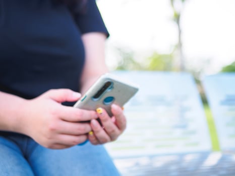 Hand young woman asian chubby cute beautiful one person wear black shirt look hand holding using smart phone in garden park outdoor evening sunlight fresh smiling cheerful happy relax summer day photo