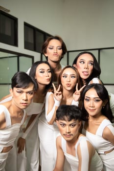 a group of Asian dancers get together and make silly faces while taking pictures on the dance floor photo