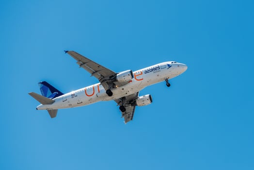 Portuguese air company Air Azores with aircraft Airbus A321-253NX approaching to land at Lisbon International Airport against blue sky photo