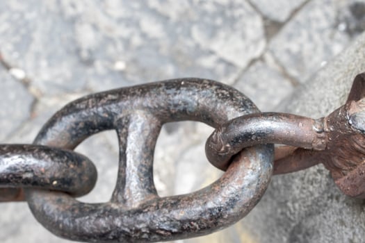 Close-up of an Old Rusty Chain Isolated. Large Chain Links on a Gray Background. The Concept of Bondage and Restriction of Freedom. Slavery. Free Space for Text photo
