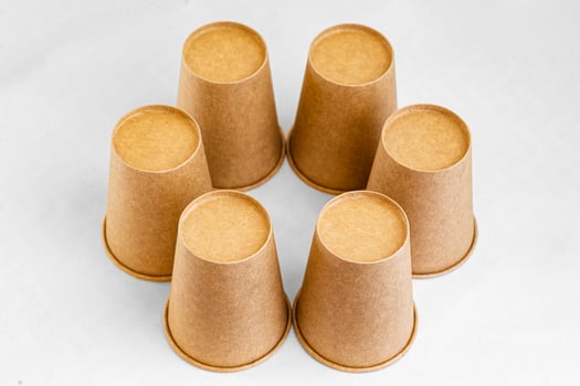 Stack of paper mugs. Six disposable paper cups made of cardboard kraft paper. photo