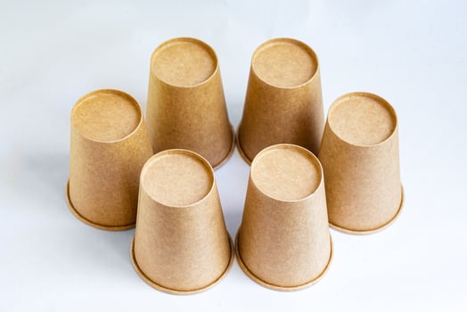 Stack of paper mugs. Six disposable paper cups made of cardboard kraft paper. photo