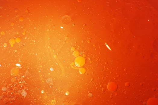 Gold Oil bubbles close up. circles of orange water macro. abstract shiny yellow background photo
