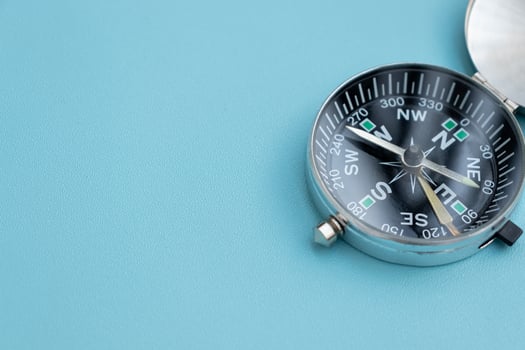 A compass isolated on blue background, after some edits. photo