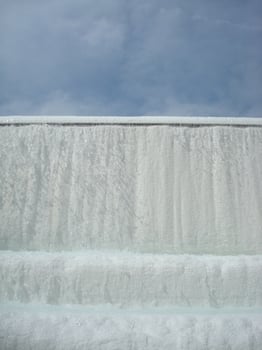a wall of snow with a person standing on top of it photo