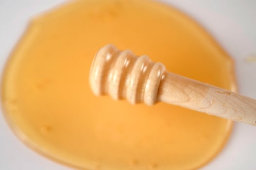 honey dripping from a wooden stick photo