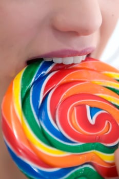 a woman holding a large lollipop photo