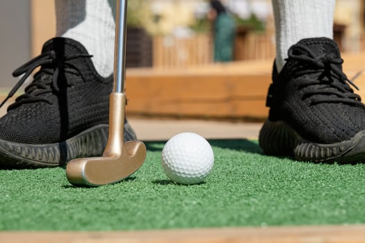 unrecognizable person playing mini golf photo