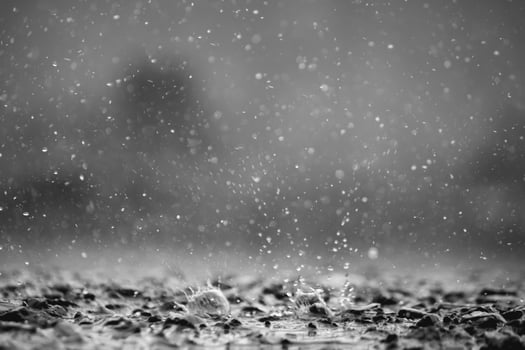 Background of many rain drops falling on the ground due to heavy rain during the rain season causing water splashing from a large number of plots on a blurred background of dark spray. photo