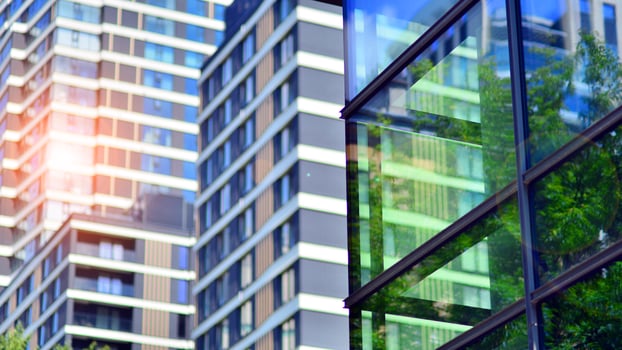 Structural glass wall reflecting blue sky. Abstract modern architecture fragment. Glass building with transparent facade of the building and blue sky. Contemporary architectural background. photo