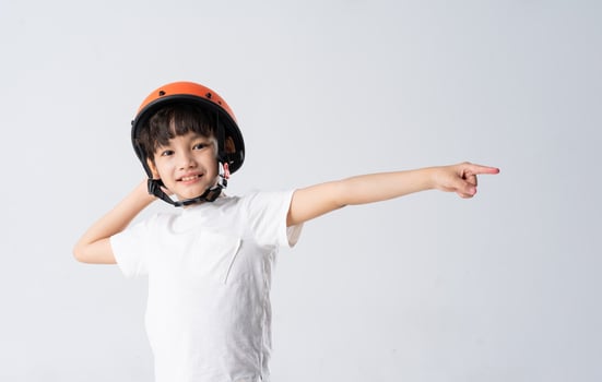 portrait of asian boy wearing orange helmet on white background photo