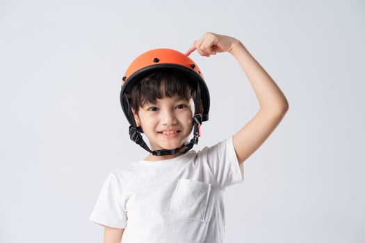 portrait of asian boy wearing orange helmet on white background photo