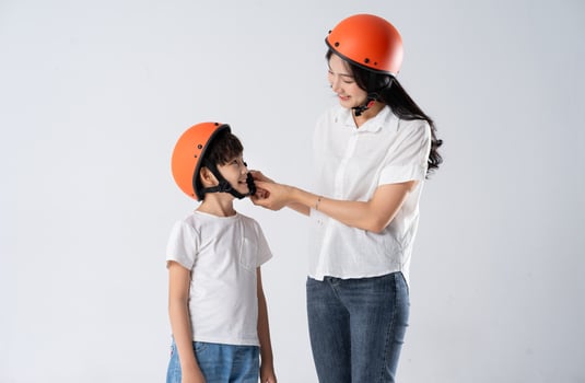 mother and son wearing helmets and riding motorbikes photo