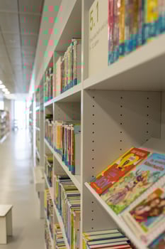 White bookshelves in the library, on which there are many books. photo