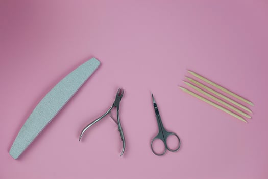 Set of tools for manicure and nail design with glitter on a pink background. photo