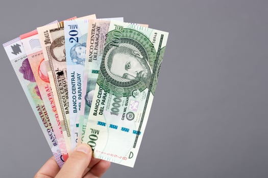 Paraguayan moneyi in the hand on a gray background photo