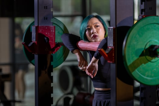 Asian woman is facing overtraining syndrome on practice weight lifting using barbell for arm and core muscle inside gym with dark background for exercising and workout photo
