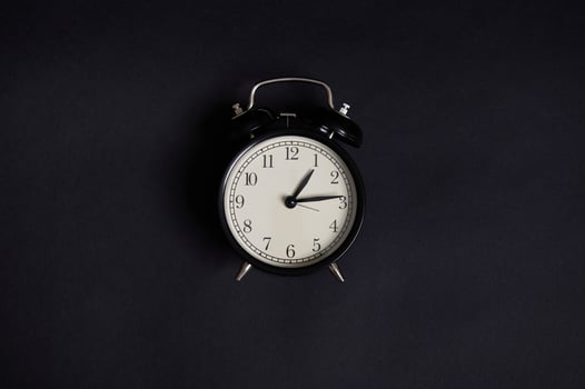 Monochrome composition with a vintage alarm clock on black background with copy space to add text. Back to School and Teachers Day Concepts, Business, Organization, Time Management. Flat lay. Top view photo
