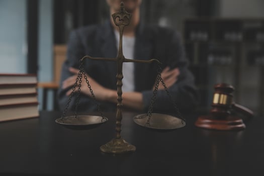 Business and lawyers discussing contract papers with brass scale on desk in office. Law, legal services, advice, justice and law concept picture with film grain effect photo