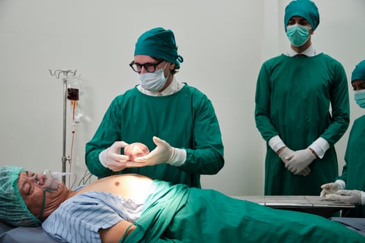 Practitioner doctors give the heart to specialist surgeons for change, medical technology, professional surgery operations on critically ill patients in hospital's ICU, and paramedic occupation. photo