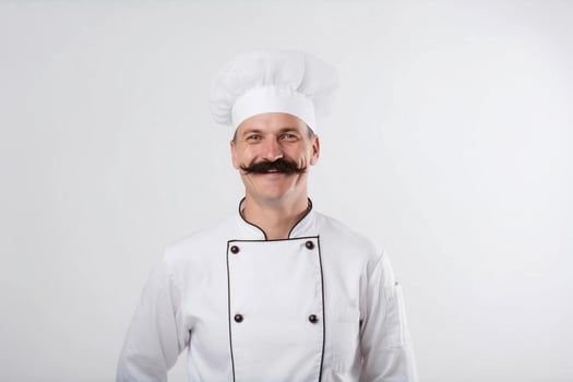 A man chef with a beard and mustache in a white uniform greets customers. White background. photo