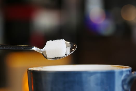 pouring white sugar cube in a coffee cup photo