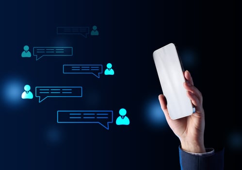 Female hand holding a smartphone and icons with dialogues nearby, group chat conversation photo