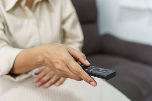 Elderly woman Watching smart TV and using remote controller Hand holding television audio remote control Middle age Asian woman movie Television series spending time at home photo